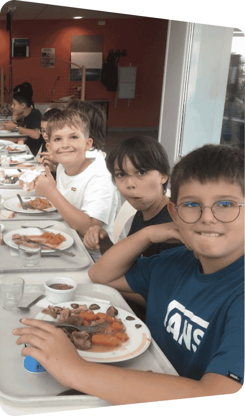Un groupe d'enfants du Collège Saint-Gilles en train de manger à la cantine